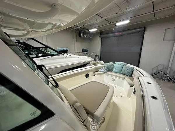 Slide: The Image of 2022 Boston Whaler 330 Outrage boat interior with seating and cushions in a showroom. - 11