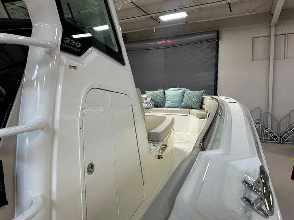Slide: The Image of 2022 Boston Whaler 330 Outrage boat interior with seating and cushions in a showroom. - 12