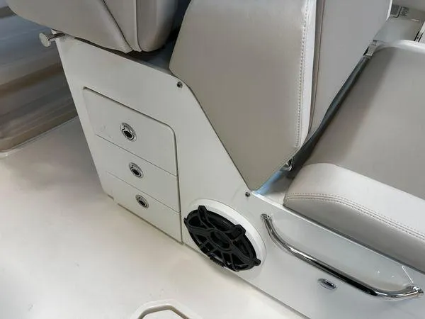 Slide: The Image of 2022 Boston Whaler 330 Outrage interior seating with storage and speaker. - 20