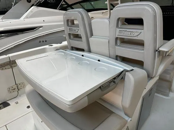 Slide: The Image of 2022 Boston Whaler 330 Outrage boat seating with foldable table and cup holders. - 22