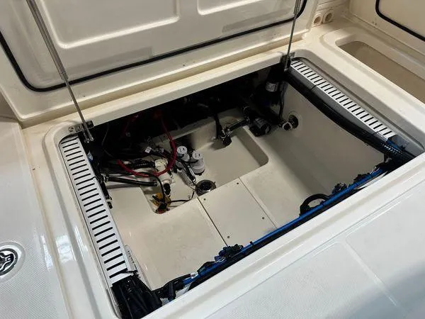 Slide: The Image of 2022 Boston Whaler 330 Outrage storage compartment with visible wiring and components. - 24