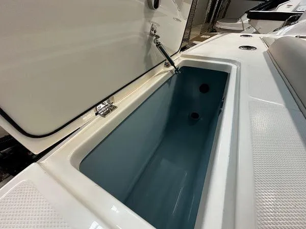 Slide: The Image of 2022 Boston Whaler 330 Outrage boat storage compartment open, showcasing interior space. - 28