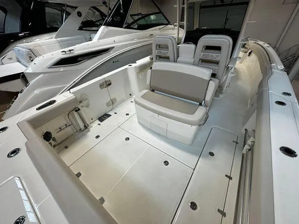 Slide: The Image of 2022 Boston Whaler 330 Outrage boat interior with seating and storage compartments. - 29