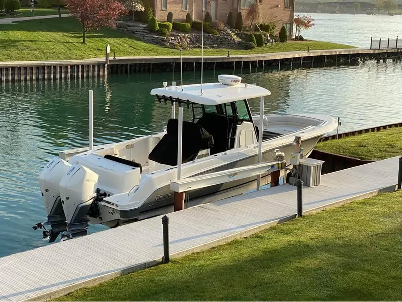 Slide: The Image of 2022 Boston Whaler 330 Outrage docked by a serene waterfront. - 3