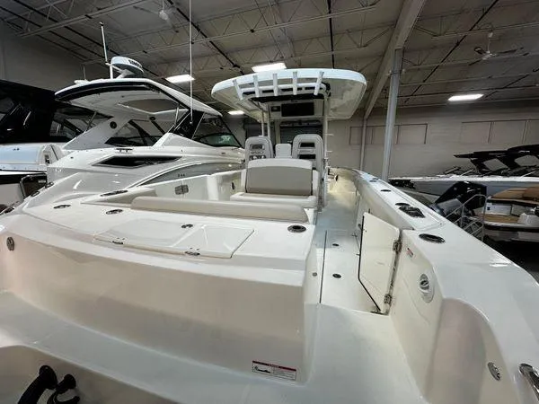 Slide: The Image of 2022 Boston Whaler 330 Outrage boat interior in showroom, showcasing seating and deck layout. - 30