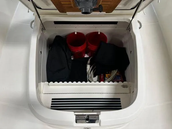 Slide: The Image of Storage compartment of 2022 Boston Whaler 330 Outrage with buckets and gear. - 7