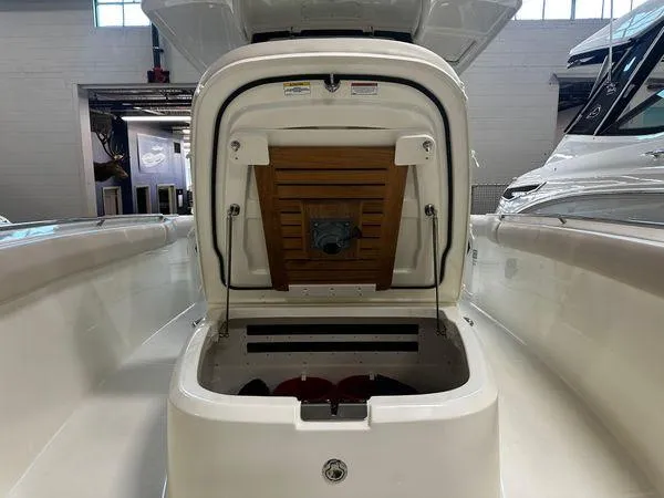 Slide: The Image of 2022 Boston Whaler 330 Outrage boat storage compartment open in showroom. - 8