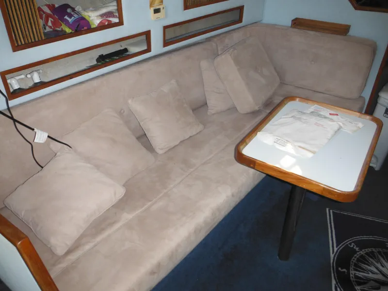 Slide: The Image of 1988 Sea Ray 270 Sundancer interior with beige seating and wooden table. - 10