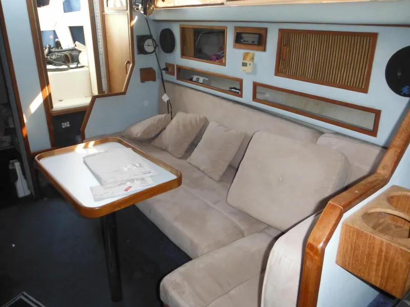 Slide: The Image of Interior of 1988 Sea Ray 270 Sundancer with beige seating and wooden accents. - 16