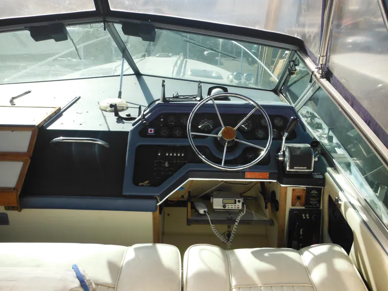 Slide: The Image of 1988 Sea Ray 270 Sundancer boat cockpit with steering wheel and control panel. - 23