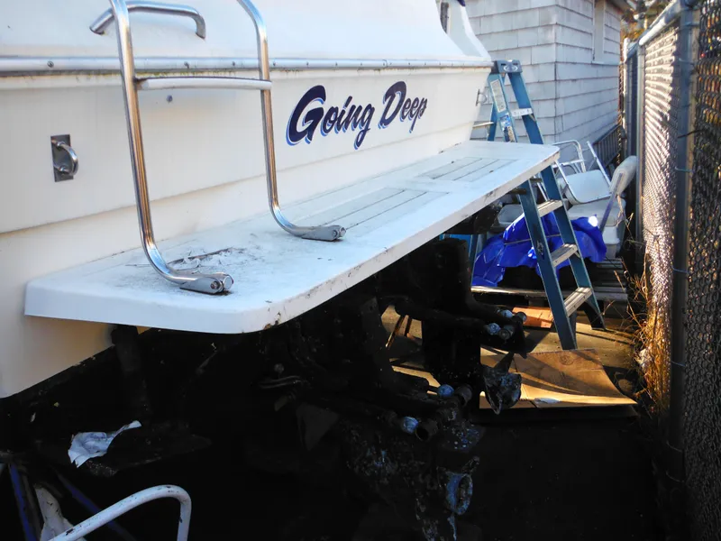 Slide: The Image of 1988 Sea Ray 270 Sundancer boat named "Going Deep" with ladder and docked setting. - 31