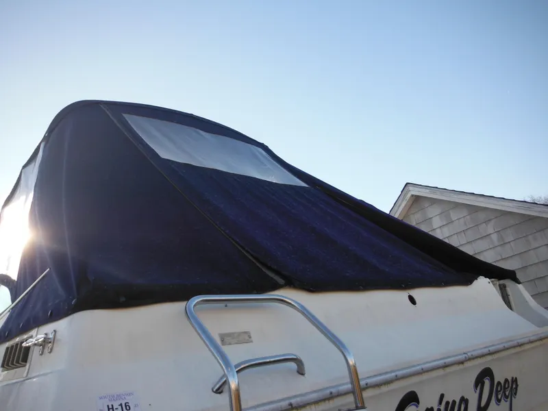 Slide: The Image of 1988 Sea Ray 270 Sundancer boat with blue canvas cover and ladder. - 32