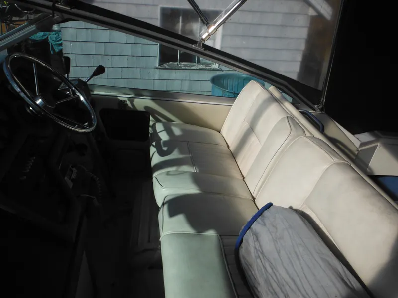 Slide: The Image of Interior of 1988 Sea Ray 270 Sundancer boat with white seating and steering wheel. - 6