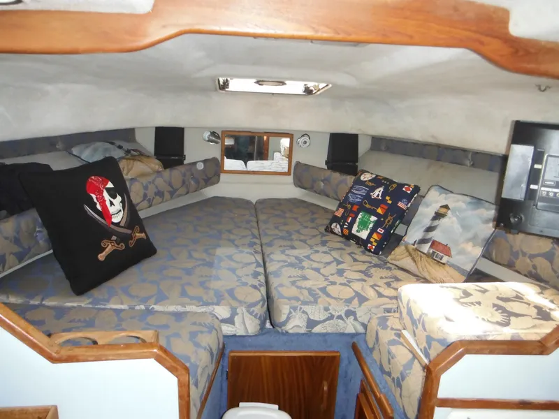 Slide: The Image of 1988 Sea Ray 270 Sundancer cabin with patterned cushions and decorative pillows. - 8