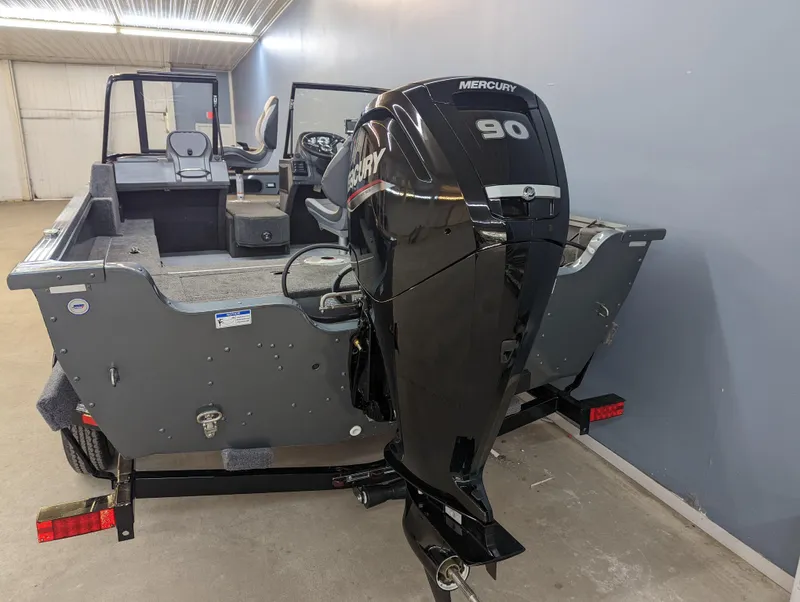 Slide: The Image of 2023 Starcraft Storm 166 DC Pro boat with Mercury 90 engine in a garage. - 2