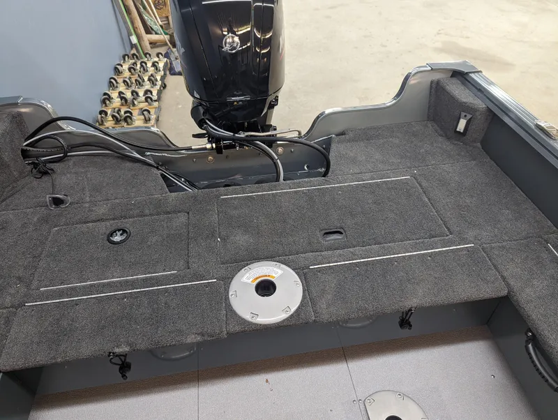 Slide: The Image of 2023 Starcraft Storm 166 DC Pro boat interior with motor and carpeted deck. - 3