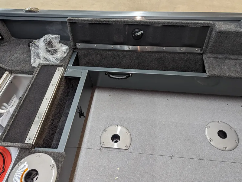 Slide: The Image of 2023 Starcraft Storm 166 DC Pro boat interior with storage compartments and carpeted flooring. - 8