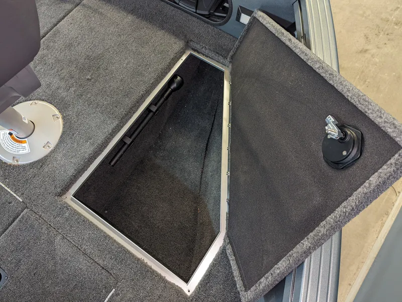 Slide: The Image of 2023 Starcraft Storm 166 DC Pro boat storage compartment, open and carpeted. - 9