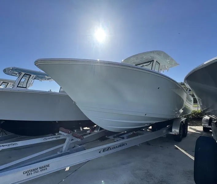 Slide: The Image of 2025 Sportsman Open 252 boat on trailer under bright sun. - 1