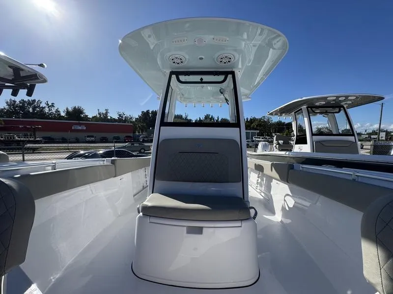 Slide: The Image of 2025 Sportsman Open 252 boat interior with seating and console under clear blue sky. - 12