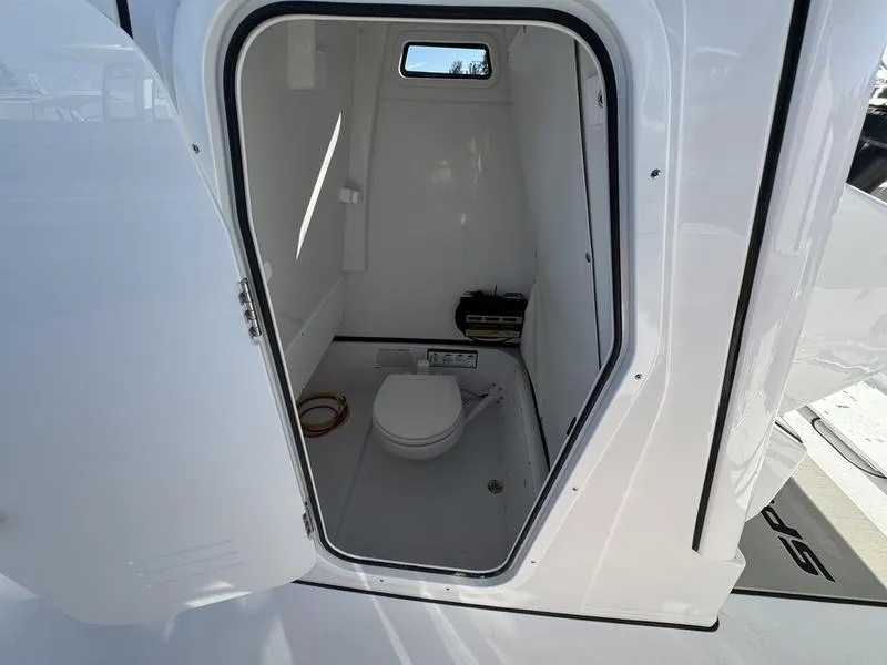 Slide: The Image of 2025 Sportsman Open 252 boat interior with compact marine toilet. - 13