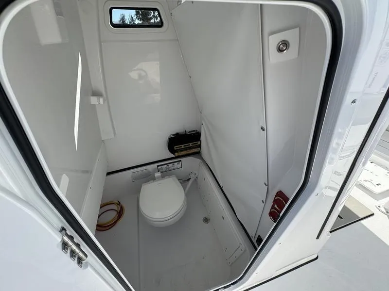 Slide: The Image of 2025 Sportsman Open 252 boat interior with compact marine toilet. - 14