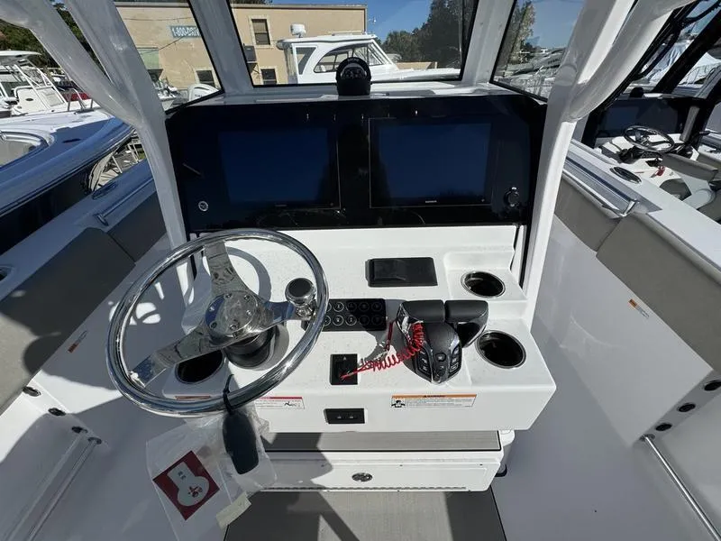 Slide: The Image of 2025 Sportsman Open 252 boat dashboard with dual screens and steering wheel. - 16