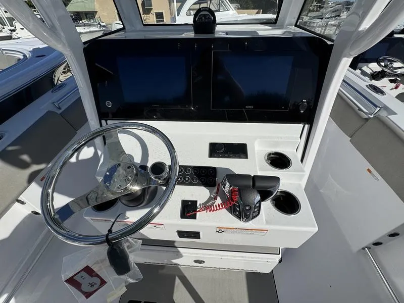 Slide: The Image of 2025 Sportsman Open 252 boat dashboard with steering wheel and controls. - 19