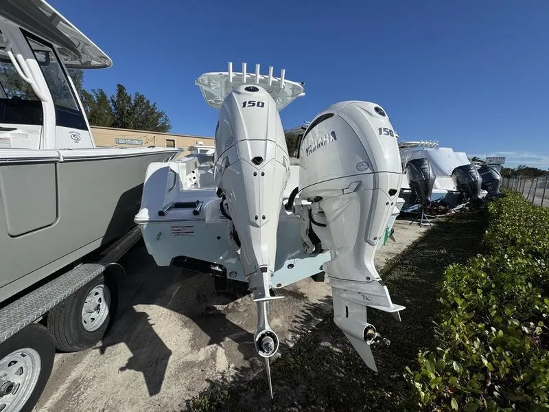 Slide: The Image of 2025 Sportsman Open 252 boat with twin Yamaha 150 engines, parked outdoors. - 2