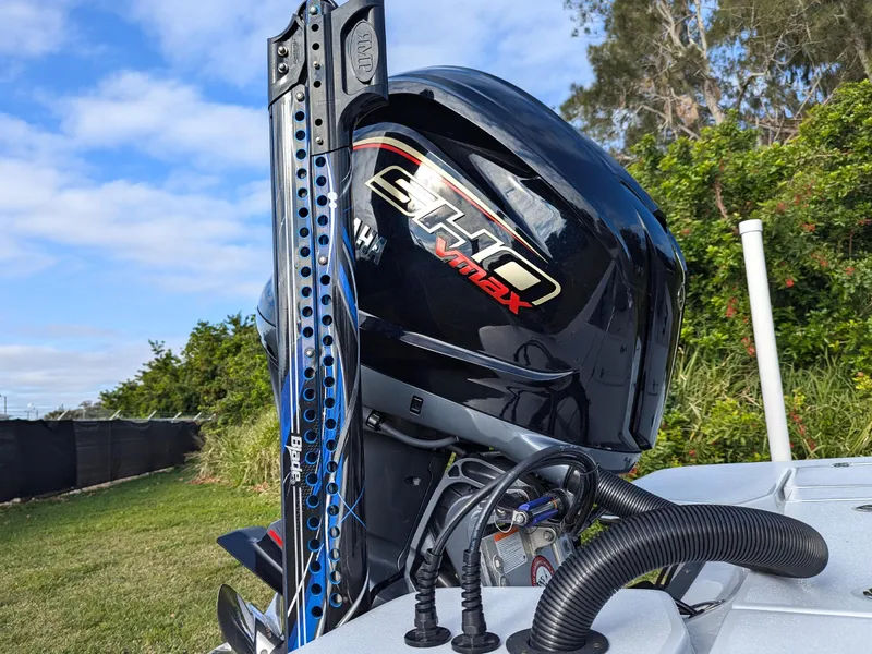 Slide: The Image of 2024 Blazer 675 Ultimate Bay with powerful outboard motor in scenic outdoor setting. - 13