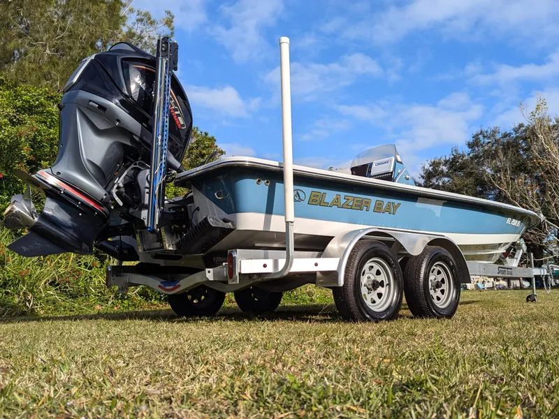 Slide: The Image of 2024 Blazer 675 Ultimate Bay boat on trailer, parked on grass. - 3