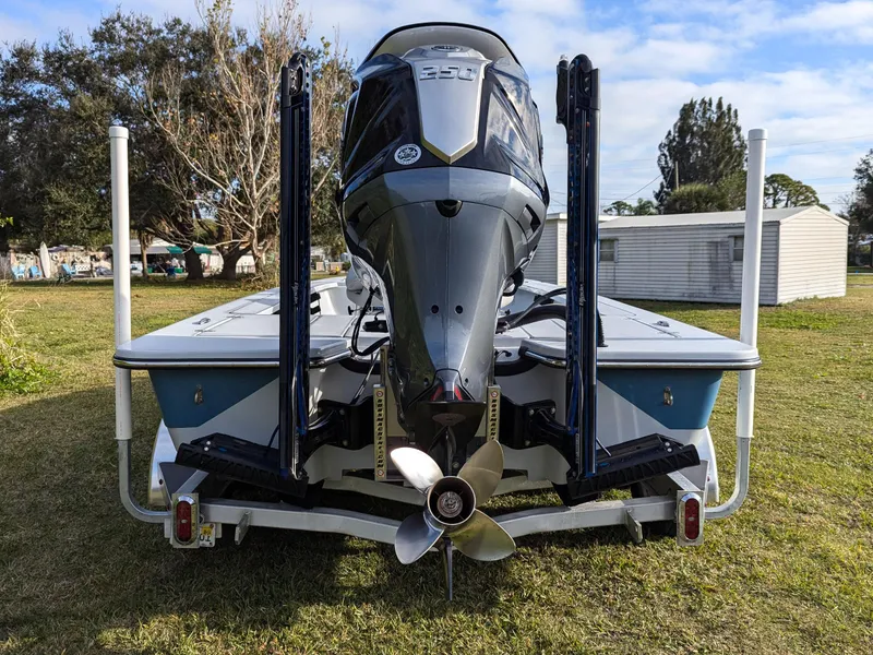 Slide: The Image of 2024 Blazer 675 Ultimate Bay boat with powerful outboard motor, parked on grass. - 4