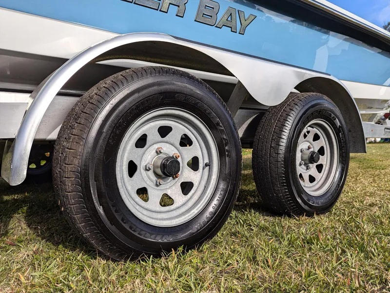 Slide: The Image of 2024 Blazer 675 Ultimate Bay trailer wheels on grass. - 5
