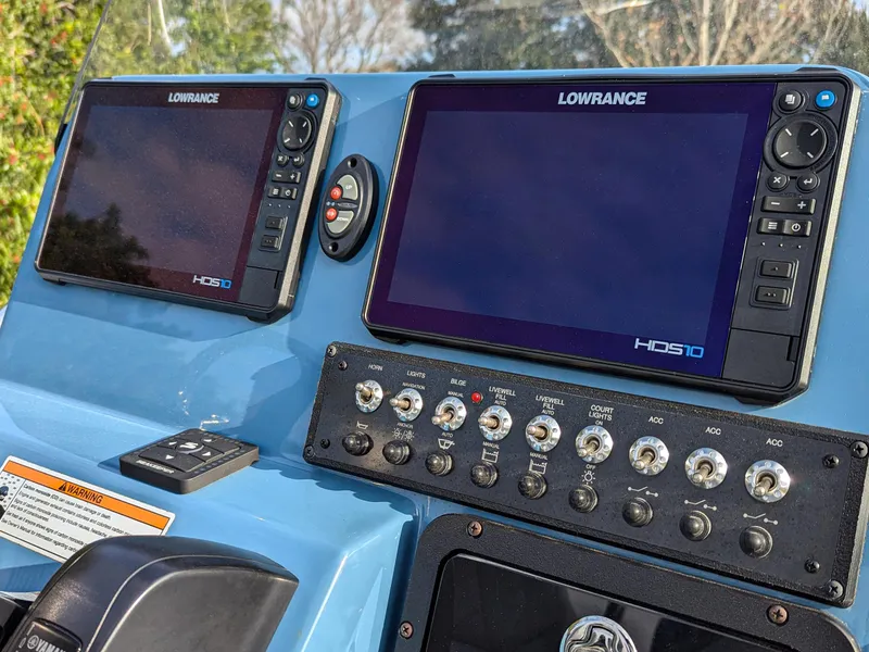 Slide: The Image of 2024 Blazer 675 Ultimate Bay boat dashboard with Lowrance HDS displays and control panel. - 8