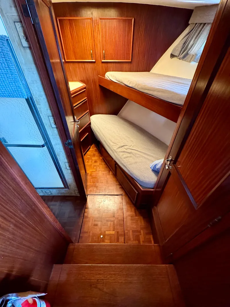 Slide: The Image of 1984 Hatteras Motor Yacht cabin with wooden interior and bunk beds. - 12