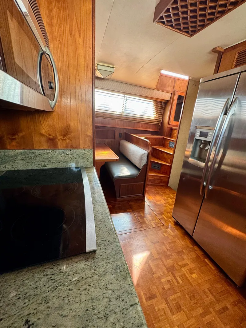 Slide: The Image of 1984 Hatteras Motor Yacht interior with kitchen, dining area, and stainless steel appliances. - 16