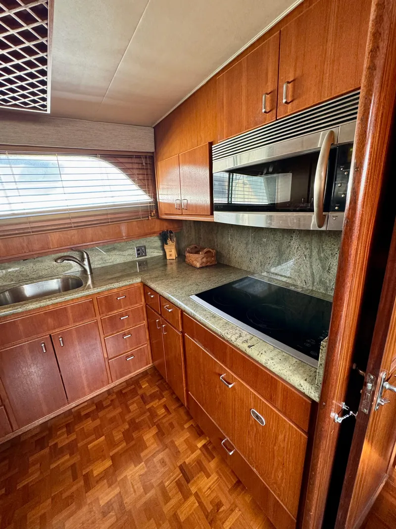 Slide: The Image of 1984 Hatteras Motor Yacht kitchen with wood cabinets, granite countertops, and modern appliances. - 17