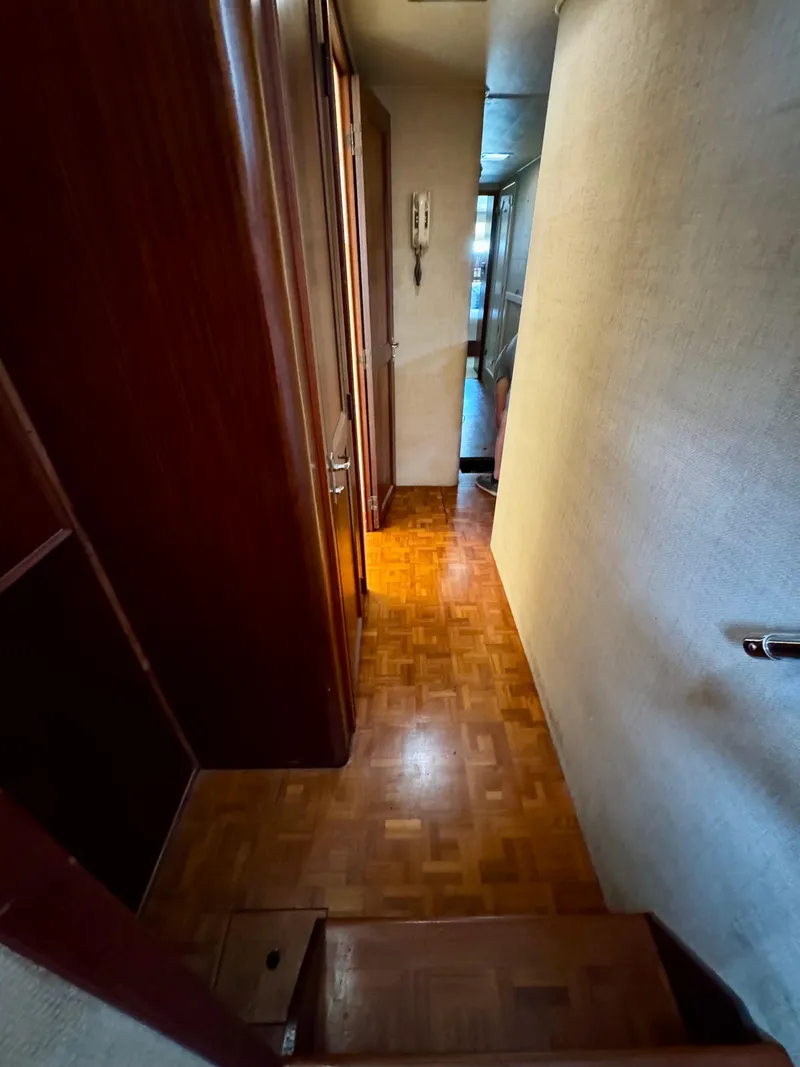 Slide: The Image of Narrow hallway inside 1984 Hatteras Motor Yacht with wooden flooring and walls. - 18