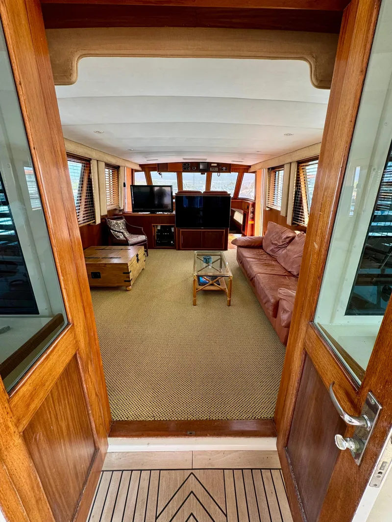 Slide: The Image of Interior of 1984 Hatteras Motor Yacht with cozy seating and wooden accents. - 2