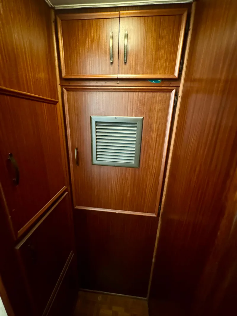 Slide: The Image of Wood-paneled interior of 1984 Hatteras Motor Yacht with vented door and cabinets. - 20