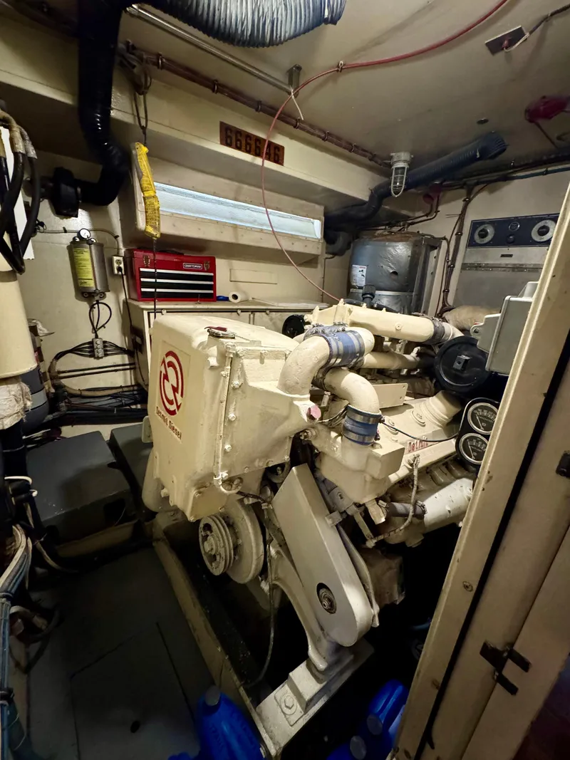 Slide: The Image of Engine room of a 1984 Hatteras Motor Yacht with visible machinery and tools. - 25