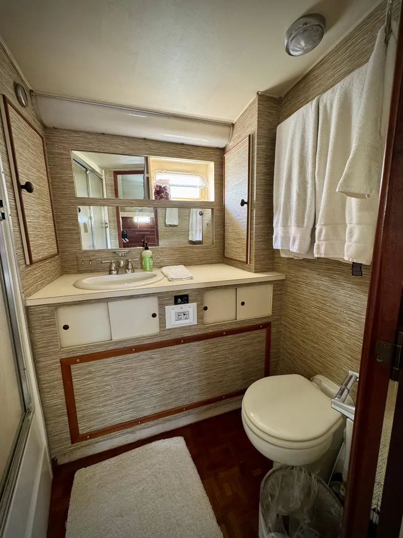 Slide: The Image of 1984 Hatteras Motor Yacht bathroom with sink, mirror, and toilet. - 28