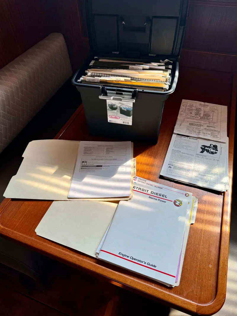 Slide: The Image of 1984 Hatteras Motor Yacht manuals and documents on a wooden table. - 31