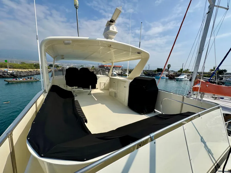 Slide: The Image of 1984 Hatteras Motor Yacht docked, featuring spacious deck and seating area. - 32