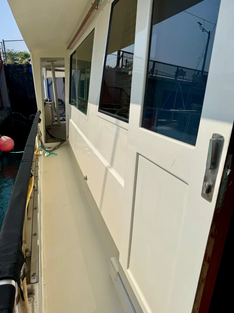 Slide: The Image of 1984 Hatteras Motor Yacht side deck with white exterior and windows. - 6