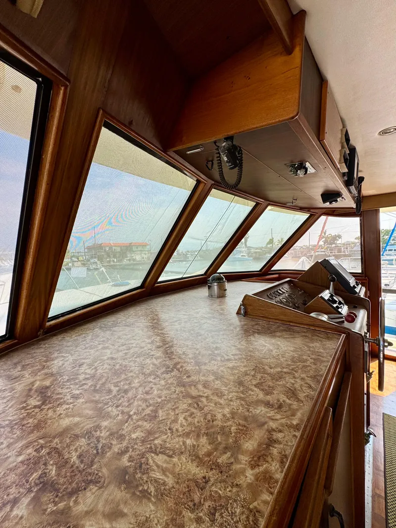 Slide: The Image of 1984 Hatteras Motor Yacht helm with wood finish and panoramic windows. - 8