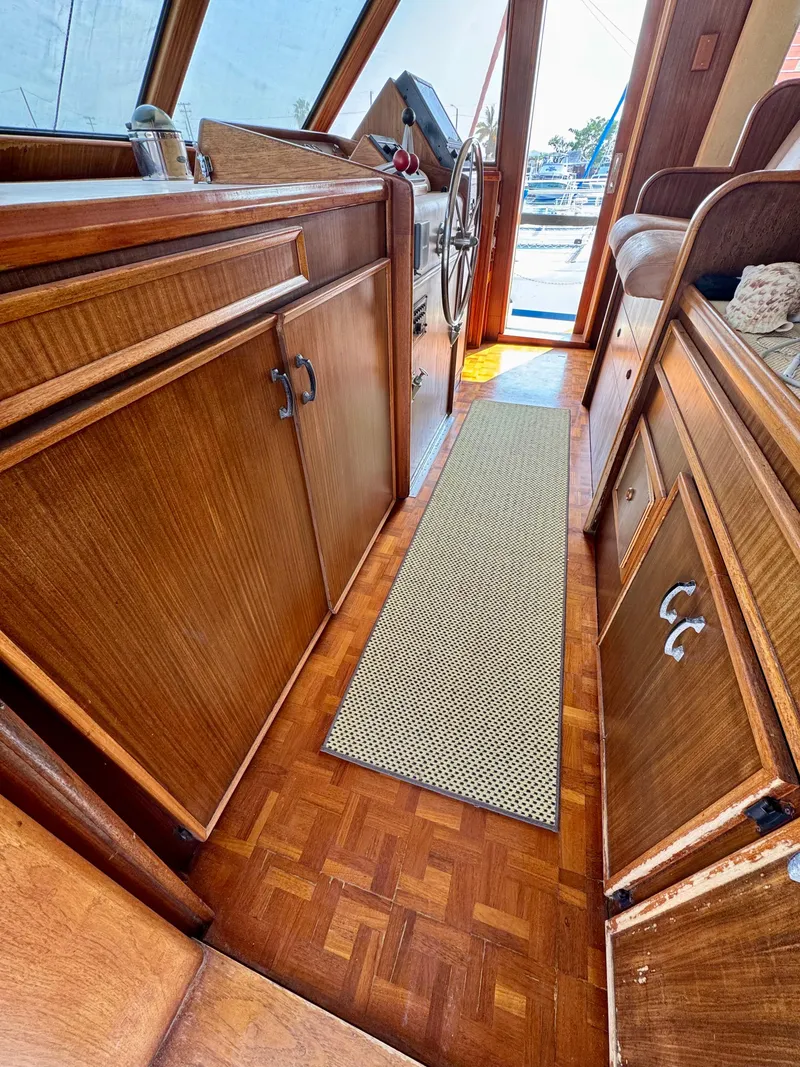 Slide: The Image of 1984 Hatteras Motor Yacht interior with wooden cabinetry and steering wheel. - 9