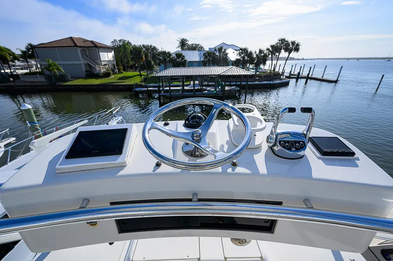 Slide: The Image of 2008 Jersey Cape Devil 36 helm with steering wheel and controls, overlooking serene waterfront. - 12