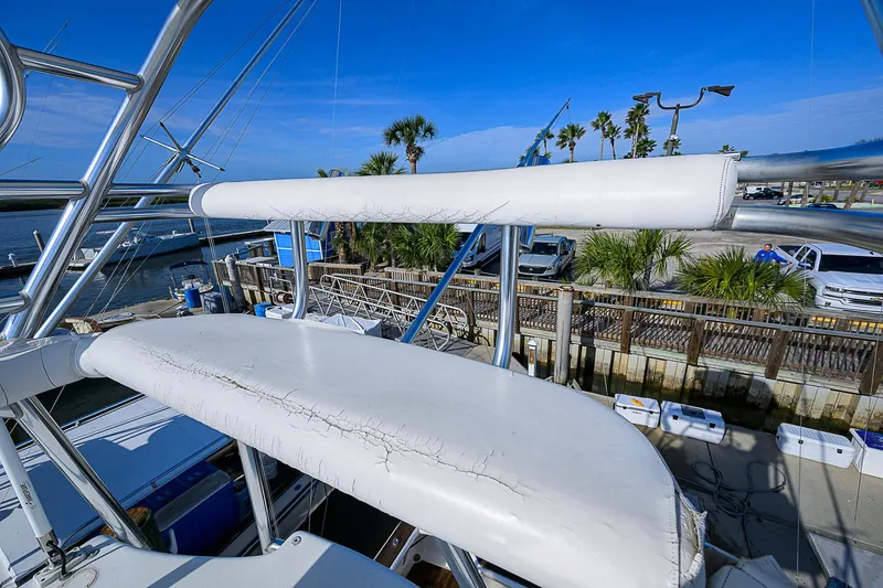 Slide: The Image of 2008 Jersey Cape Devil 36 boat with worn seating, docked near palm trees. - 14