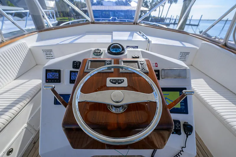 Slide: The Image of 2008 Jersey Cape Devil 36 boat helm with wooden steering wheel and navigation instruments. - 17